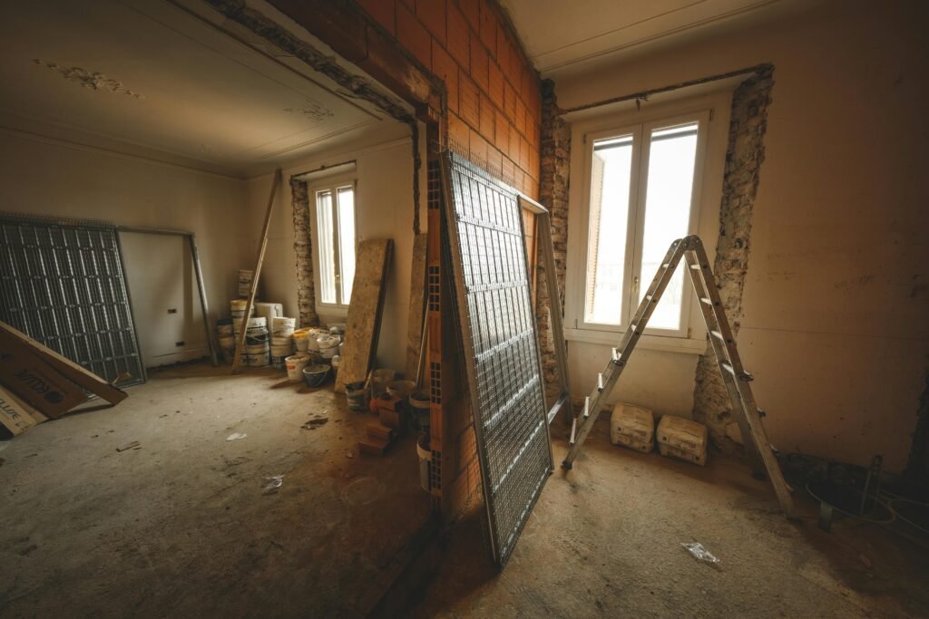 Interior view of a room under renovation with construction materials and a ladder.